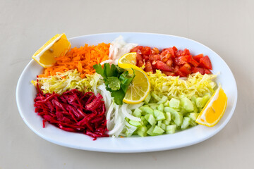 Green salad with arugula, lamb and tomatoes. Healthy vegan dish. Top view at table. Turkish Coban (choban) salata or Shepherds salad, Akdeniz salad in white bowl.