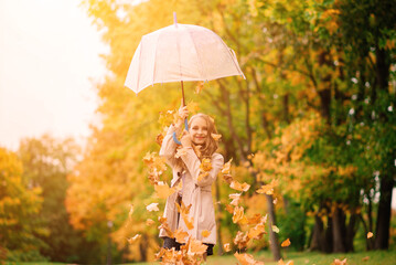 Young attractive smiling girl under umbrella in autumn forest