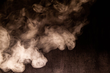 Billowing cloud of white smoke against dark background.