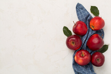 Fresh red apples with leaves on concrete background, top view