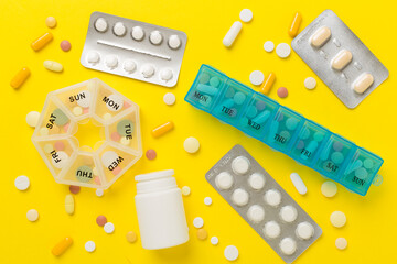 Daily pill box with medications on color background, top view