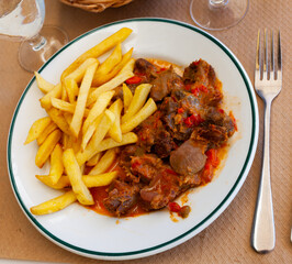 Chicken gizzards stewed in vegetable sauce served with French fries