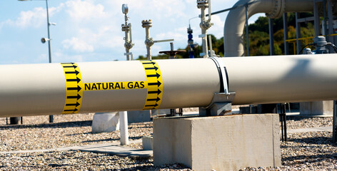 Metal gas pipeline pipe with background of various equipment and inscription