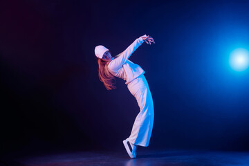 a girl in light clothes dances on a neon background in smoke, modern dance