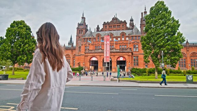 A female tourist visits Kelvingrove Art Gallery and Museum in Glasgow, Scotland. Collection of diverse Scottish and international art with natural history displays in Glasgow.
