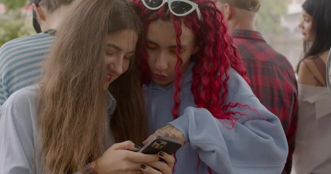 Happy teens Girls using smartphone. Visual content, including photos and videos, enhances memory preservation. It allows users to tell vivid stories, evoke emotions, and create a lasting impression.