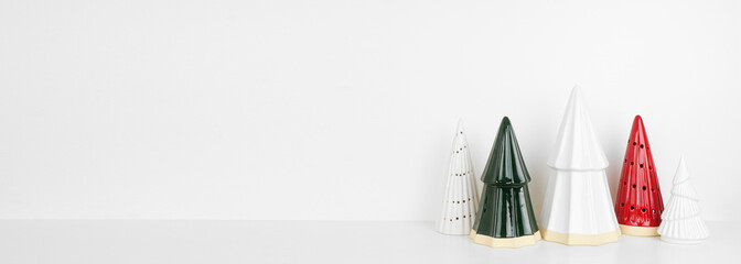 Christmas tree decor on a white shelf against a white wall banner background with copy space