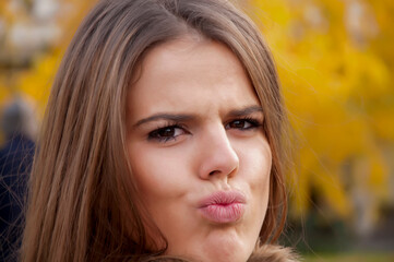 Fototapeta premium Portrait of a young attractive long haired brunette in the park