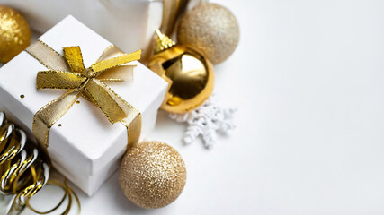 Gold and white christmas decor with a white giftbox tied bow and golden ribbon - traditional indoor holiday decoration