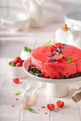 Homemade strawberry cake with red glaze and whipped cream.
