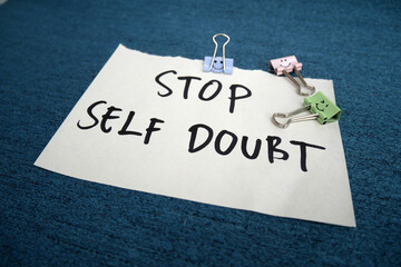 Handwritten message paper STOP SELF DOUBT, concept of self worth , stop striving for approval, more...