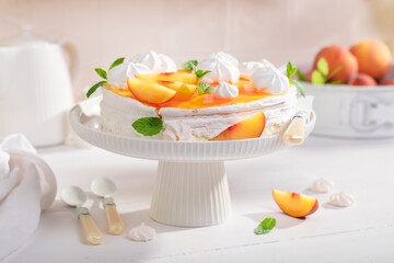 Sweet peach meringue with powdered sugar and fruits.