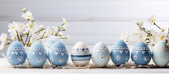 Obraz na płótnie Canvas Blue felt Easter eggs made by hand arranged on a white wooden table with patchwork design
