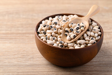 Black eye peas or cowpeas in bowl and spoon on wooden background, Food ingredients