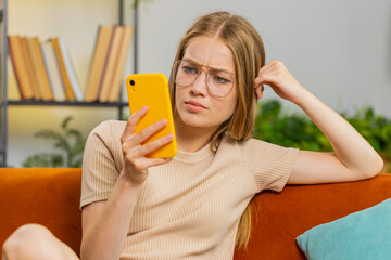 Sad displeased woman use smartphone typing browsing, loses becoming surprised sudden lottery...
