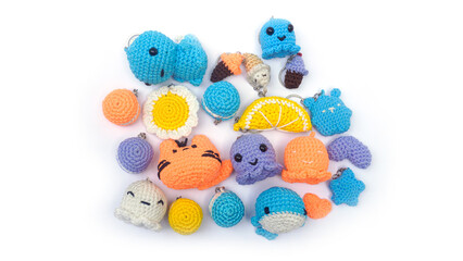 Amigurumi. Assorted shapes of mini keychains in several colors crocheted on a white background. Handmade crocheted soft keychain.