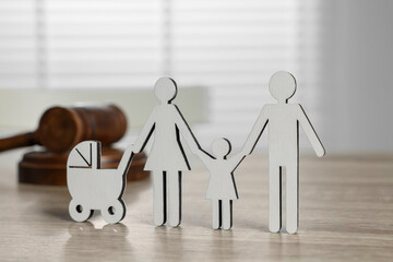 Family law. Figure of parents with children and gavel on light wooden table - obrazy, fototapety, plakaty