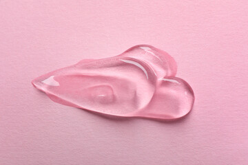 Swatches of cosmetic gel on pink background, top view