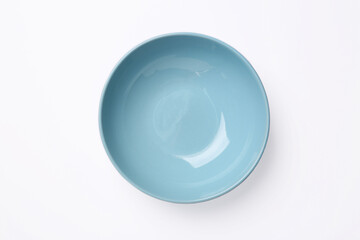 One clean plate on white background, top view. Ceramic dinnerware