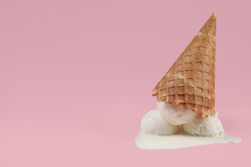 Melting ice cream and wafer cone on pink background, space for text