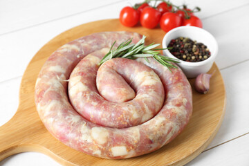 Raw homemade sausage, rosemary, garlic and peppercorns on white wooden table, closeup