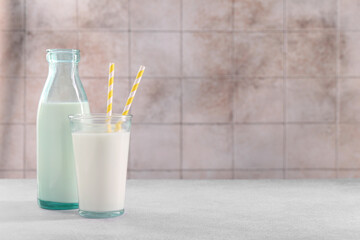 Glassware with tasty milk on light gray table, space for text