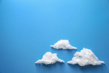 Clouds made of cotton on blue background. Space for text
