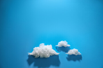 Clouds made of cotton on blue background. Space for text