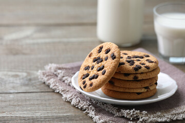 Delicious chocolate chip cookies on wooden table, space for text