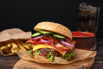 Tasty burger with bacon, vegetables and patty on wooden table, closeup