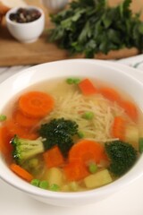 Delicious vegetable soup with noodles on table, closeup