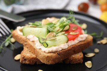 Fototapeta na wymiar Tasty vegan sandwich with cucumber, tomato and pumpkin seeds on plate, closeup