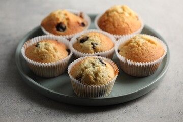 Delicious sweet muffins with berries on grey table