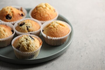 Delicious sweet muffins with berries on grey table, closeup. Space for text