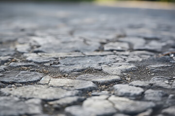 Obraz premium Close up view of an abandoned road, cracked and weathered surface, exterior material texture