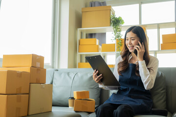 Small business entrepreneur or freelance Asian woman working with parcel boxes Young successful woman with packaging boxes, online marketing and her delivery, SME business concept