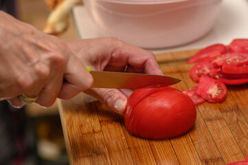 woman cutting tomato on kitchen board 3