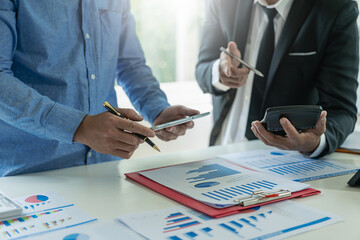 business team working They are analyzing financial reports and using calculators. accounting calculations And partners point to financial reports to analyze the company's sales plans.