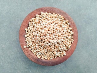 pile of coriander seeds in wooden bowl on gray background. herbs and spices. spices. Top view

