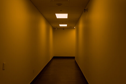 Empty hallway - dimly lit - orange glow - fluorescent light
