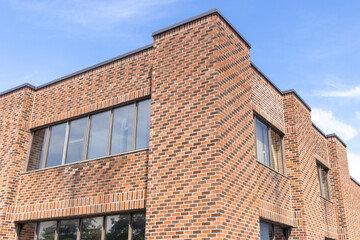 Brick building with windows - blue sky with clouds - architecture