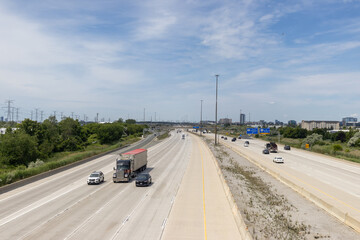 Highway traffic - daytime - few cars and trucks - blue sky - overpass view
