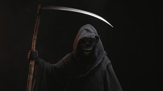 Skeleton, skull, silhouette of a man in a black robe, depicting death holding a scythe. The scary grim reaper. Death Grim Reaper Costume for Halloween. Halloween characters concept.