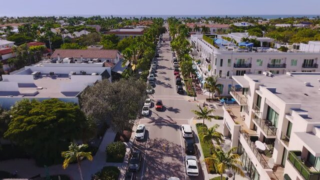 Aerial view of 5th avenue in downtown Naples Florida, with Gulf of Mexico view in the distance and luxury residences and businesses along the avenue.