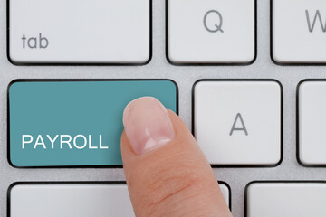 Woman pressing turquoise button with word Payroll on keyboard, top view