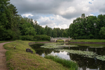View of the Slavyanka River and the Viscontiev Bridge in the Pavlovsk Palace and Park Complex on a sunny summer day, Pavlovsk, Saint Petersburg, Russia