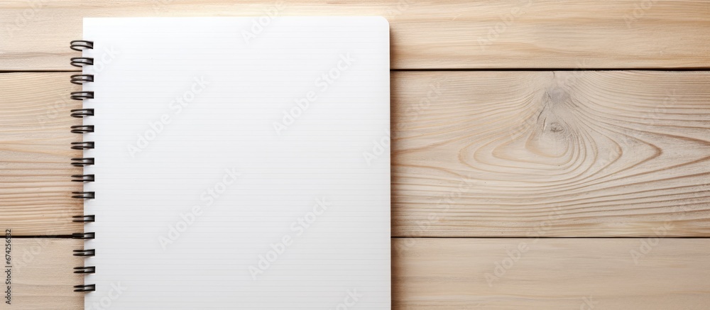 Sticker a light wooden background showcasing an empty space notebook from a top perspective