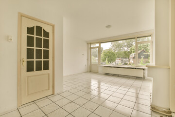 an empty room with white tile flooring and large windows looking out onto the street in front of the house