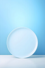 White round dish on kitchen table top in light blue wall background