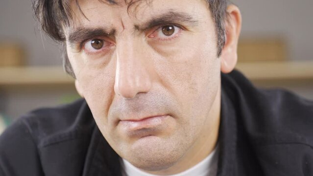 Man looking angry at camera. Big eyes.